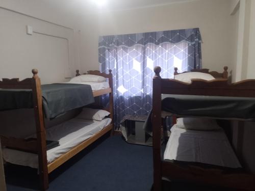 a room with two bunk beds and a blue carpet at La tranquila termal in Termas de Río Hondo