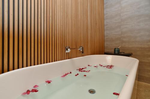 a bath tub with flowers on the side of it at Bridle Path Retreat - Christchurch Holiday Homes in Christchurch