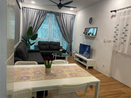 een woonkamer met een tafel en een bank bij Teratak Al-Kautsar Homestay in Kuching