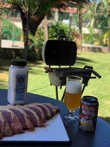 a table with a grilled sausage and a glass of beer at Duplex Beira-mar em condomínio / Búzios-RN in Nísia Floresta