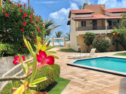 a villa with a swimming pool and a house at Duplex Beira-mar em condomínio / Búzios-RN in Nísia Floresta