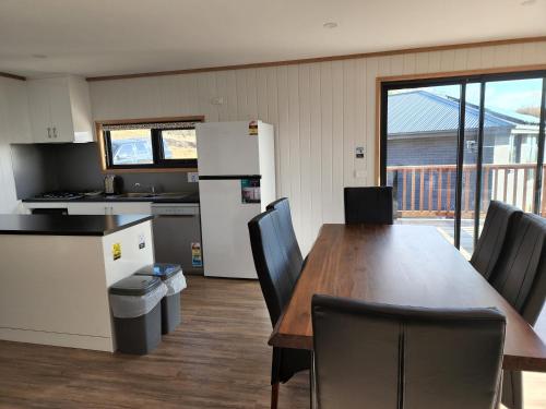 a kitchen and dining room with a table and chairs at Mount Rumney Escapes - 3 Seaview Wombat House in Mount Rumney