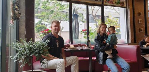 a man and a woman and a child sitting in a restaurant at BBQ HOSTEL in Ha Long