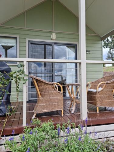 a porch with two chairs and a table at Grace Cottages in Uralla