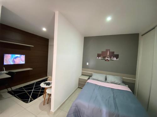um quarto com uma cama e uma televisão de ecrã plano em Flat aconchegante próximo a Pelinca em Campos dos Goytacazes