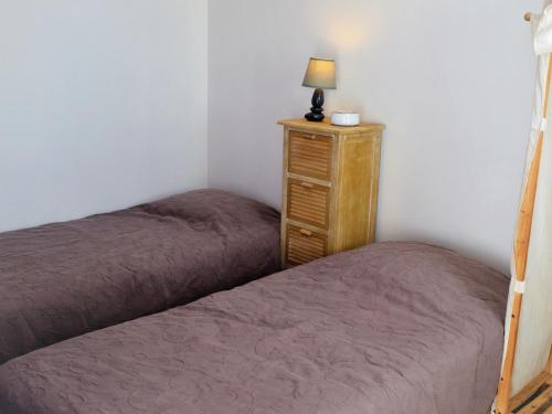 ein Schlafzimmer mit 2 Betten und eine Kommode mit einer Lampe in der Unterkunft Maison La Tranche-sur-Mer, 2 pièces, 4 personnes - FR-1-22-256 in La Tranche-sur-Mer