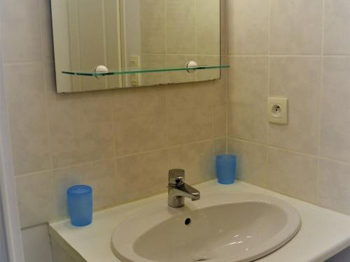 a bathroom with a sink and a mirror and blue cups at Maison proche plage et commerces à La Tranche-sur-Mer - FR-1-22-256 in La Tranche-sur-Mer