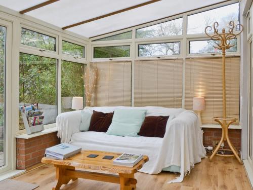 a living room with a white couch and windows at Damson Lodge in Chetton