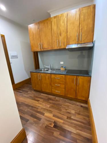 a kitchen with wooden cabinets and a wooden floor at RIALTO SUITES Fremantle in Fremantle