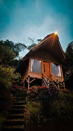 uma pequena casa com uma escada que leva até ela em Saung Arjuna Syandana Resort em Ciwidey