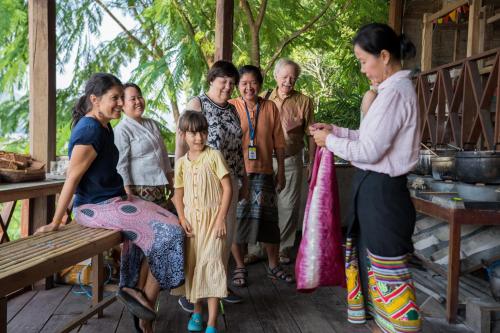 a group of people standing on a porch at Ock Pop Tok Mekong Villa in Luang Prabang
