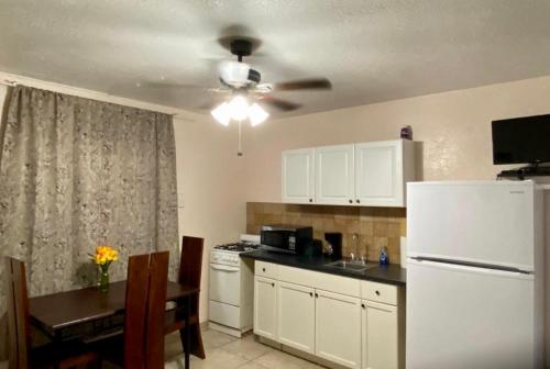 a kitchen with a white refrigerator and a table at Hallandale Beach Motel in Hallandale Beach