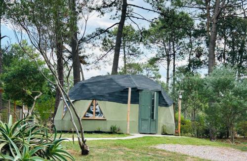 ein kleines Haus mit schwarzem Regenschirm im Hof in der Unterkunft Cuchilla Alta domo geodésico in Cuchilla Alta