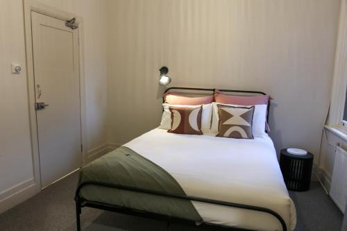 a bedroom with a large bed with many pillows at Alpine Hotel, Eat Drink Sleep in Warburton