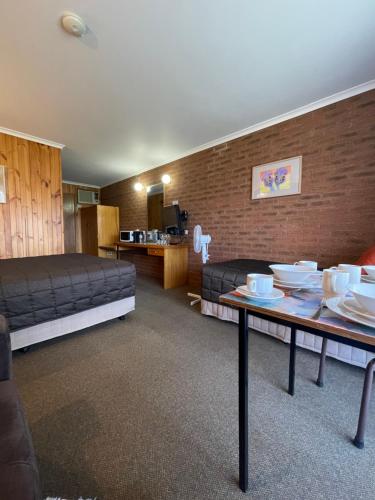 ein Zimmer mit einem Bett und einem Tisch mit Tellern darauf in der Unterkunft Country Roads Motor Inn in Narrandera
