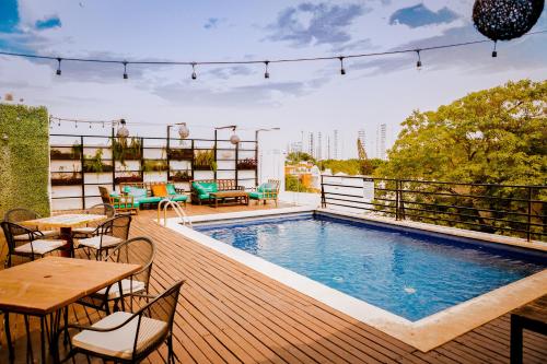 um deque com piscina no topo de um edifício em Nomads Hotel, Hostel & Rooftop Pool Cancun em Cancún