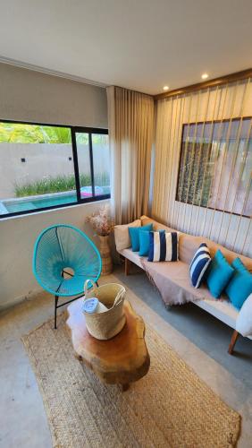 ein Wohnzimmer mit einem Sofa und einem Tisch in der Unterkunft Kai Milagres Beach House in São Miguel dos Milagres