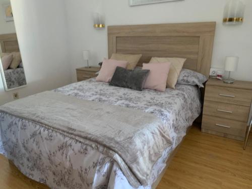 um quarto com uma cama grande e almofadas cor-de-rosa em Estudio Roquetas em Roquetas de Mar
