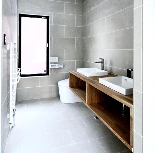 a bathroom with two sinks and a mirror at DREAM LIFE Onsen Villa in Niseko