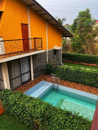 a swimming pool in front of a house at Enliven Homestay Alibag, Alibaug in Nagaon