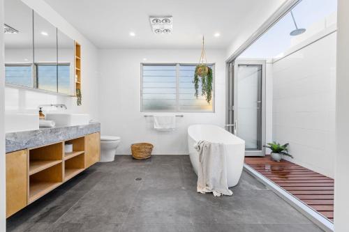 a bathroom with a tub and a sink at Daybreak at Currumbin in Gold Coast