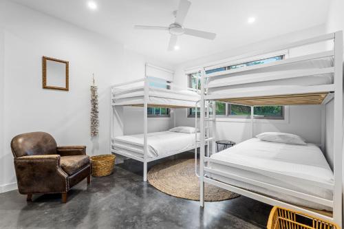a bedroom with two bunk beds and a chair at Daybreak at Currumbin in Gold Coast