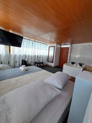 a large bedroom with two beds and a sink at Hotel Alpamayo Guest House in Huaraz