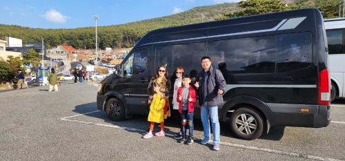 a family is standing in front of a van at Denbasta Central Hotel Seomyeon in Busan