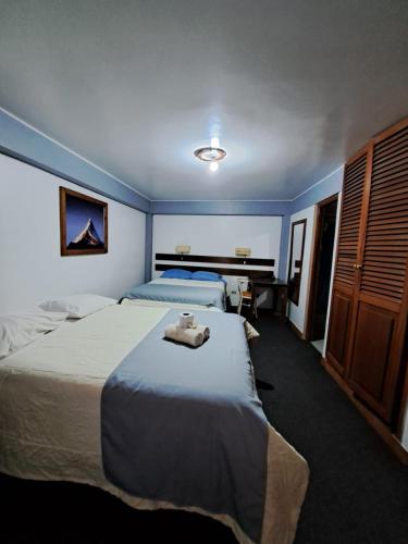 a hotel room with two beds and a large bed at Hotel Alpamayo Guest House in Huaraz
