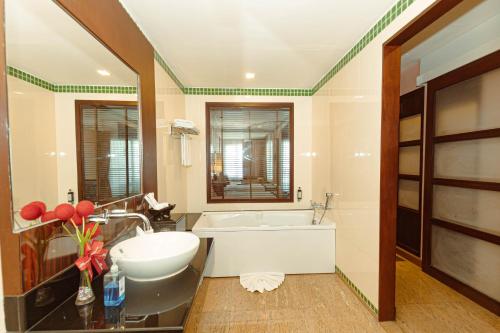 y baño con lavabo, bañera y espejo. en Grand Pacific Sovereign Resort & Spa, en Cha Am