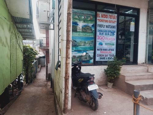 a motorcycle parked in front of a building at NatureswayBudget room Travel in Coron