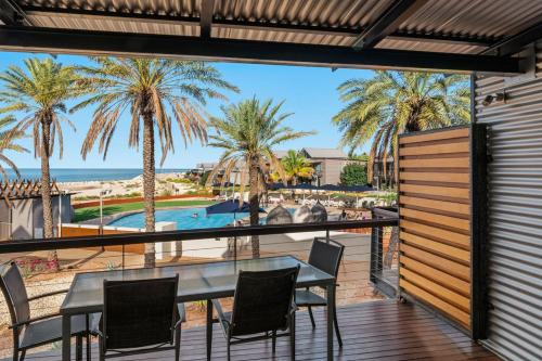 - Balcón con mesa y sillas y vistas a la playa en Mantarays Ningaloo Beach Resort, en Exmouth