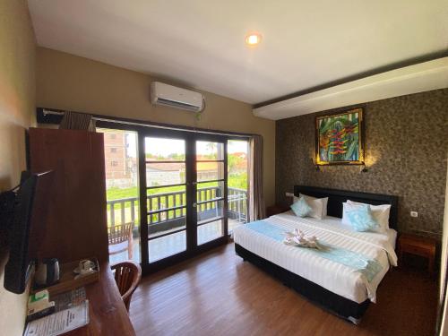 a bedroom with a bed and a balcony at Kent Beach House in Canggu