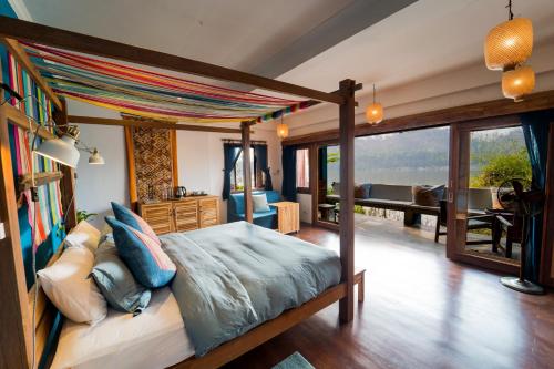 Ock Pop Tok Mekong Villa في لوانغ برابانغ: غرفة نوم مع سرير وغرفة معيشة
