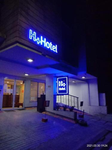 un hotel con un cartello sulla parte anteriore di notte di H Plus Hotel powered by Cocotel a Manila
