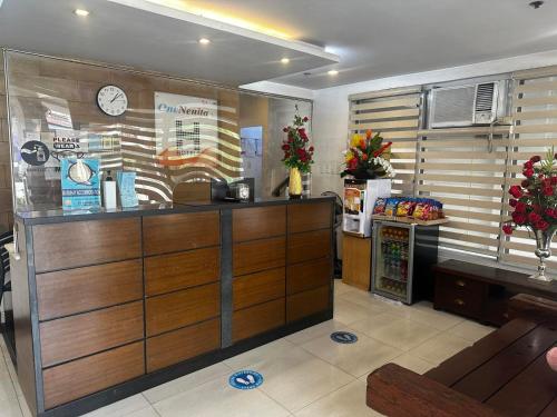 un ristorante con cassa e bancone con orologio di H Plus Hotel powered by Cocotel a Manila