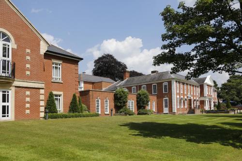 ein großes Backsteingebäude mit einem großen Rasenplatz in der Unterkunft Manor Hotel Solihull, BW Signature Collection in Bickenhill