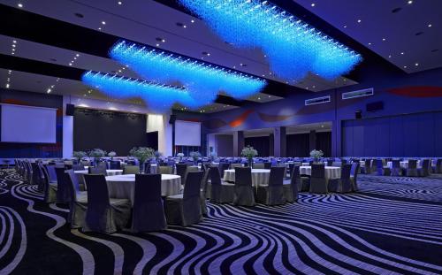 a ballroom with tables and chairs and blue lights at Wyndham Grand Bangsar Kuala Lumpur in Kuala Lumpur
