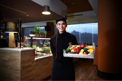 a man is holding a box of fruit at Wyndham Grand Bangsar Kuala Lumpur in Kuala Lumpur
