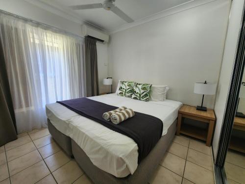 um quarto com uma cama grande e uma janela em Central Plaza Port Douglas em Port Douglas
