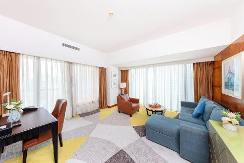珠海市にあるHampton by Hilton Zhuhai Gongbei Portのリビングルーム(青いソファ、テーブル付)