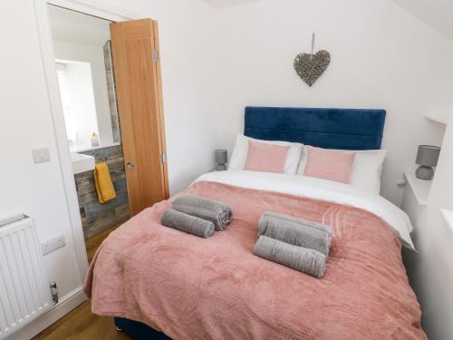 a bedroom with a large bed with two pillows on it at Star Cottage in Saundersfoot