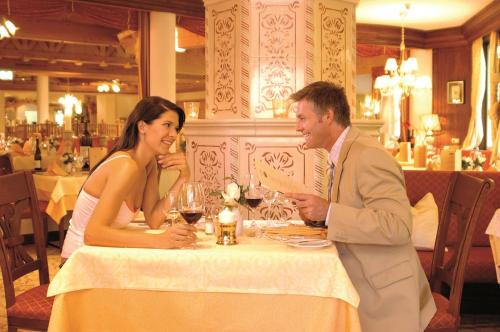 a man and woman sitting at a table in a restaurant at Wellnesshotel Schönruh - Adults only in Seefeld in Tirol