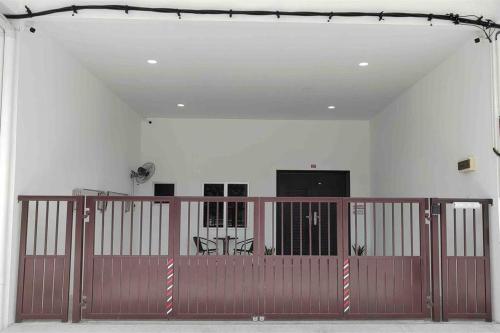 實兆遠的住宿－New Single Storey Homestay @ Sitiawan 3R2B (6-9PAX) _Feb Moment Homestay，白色墙壁的房间里,有一个棕色的大门