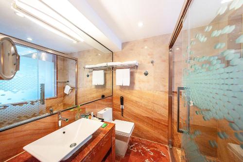 a bathroom with a sink and a glass shower at Hampton by Hilton Zhuhai Gongbei Port in Zhuhai