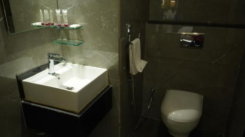 a bathroom with a sink and a toilet at Purple Beds by VITS - Dwarkesh, Surat in Salabatpura