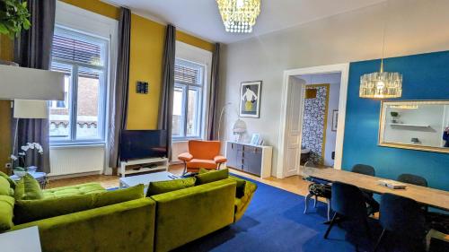 a living room with a green couch and a table at Great Synagogue Apartment, 2 separate bedrooms, 5 guests, Fast Wifi,AC in Budapest