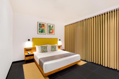 a bedroom with a large bed and a large window at Keys Prima By Lemon Tree Hotels, Thekkady in Thekkady
