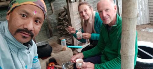 a group of three men sitting around a fire at Kabiraalaya Homestay in Darjeeling