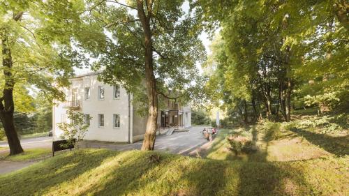 a house with a tree in front of a street at Downtown Forest Hostel & Camping in Vilnius